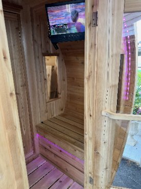 Inside the sauna — cedar benches, purple LED light and a TV mounted on the wall